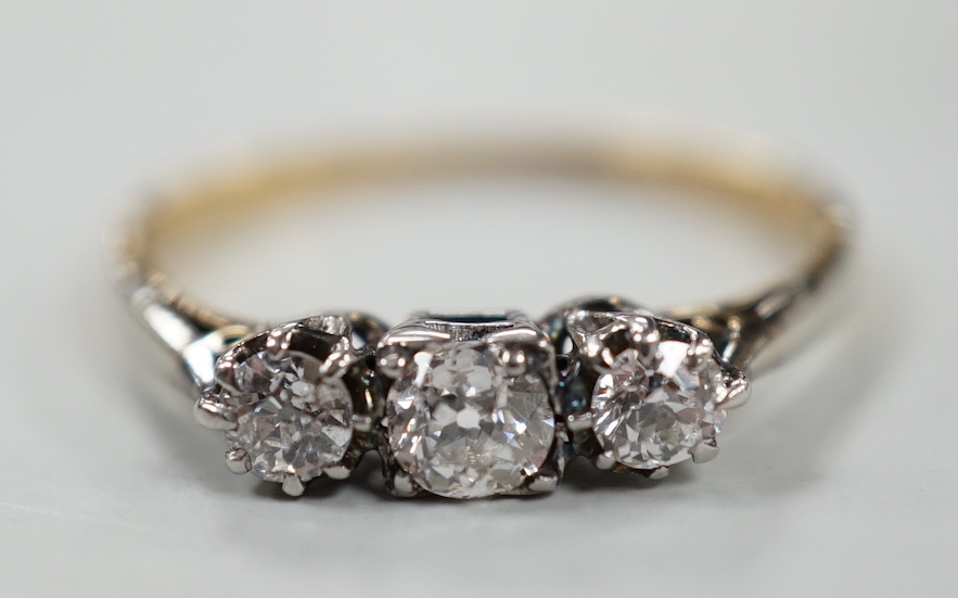 A yellow metal, plat and three stone diamond set ring, size P, gross weight 2 grams.